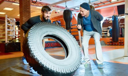 Sportsman flipping tire with coach near