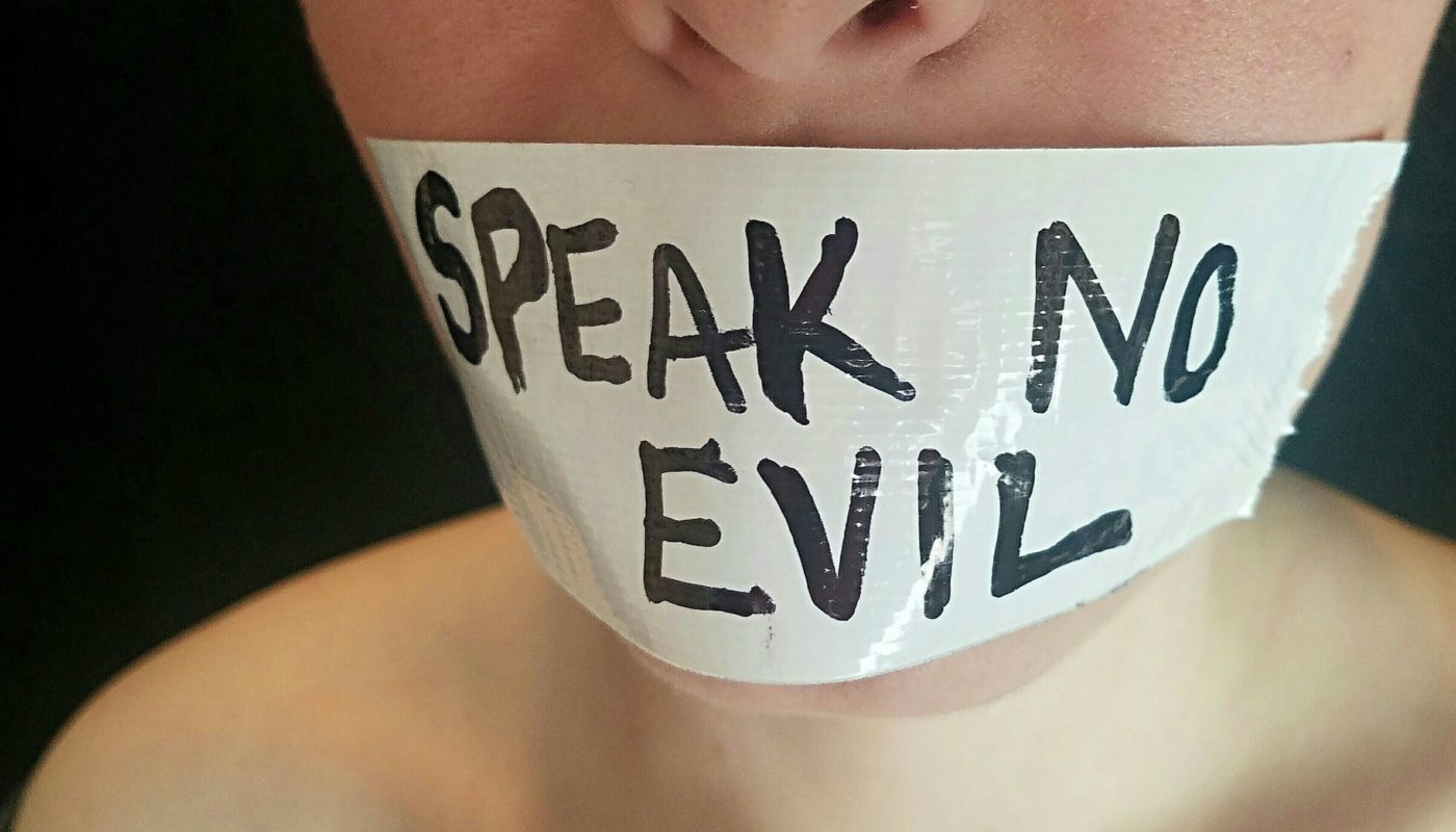 Words Can Hurt: Conceptual image of Speak No Evil written on duct tape covering mouth.